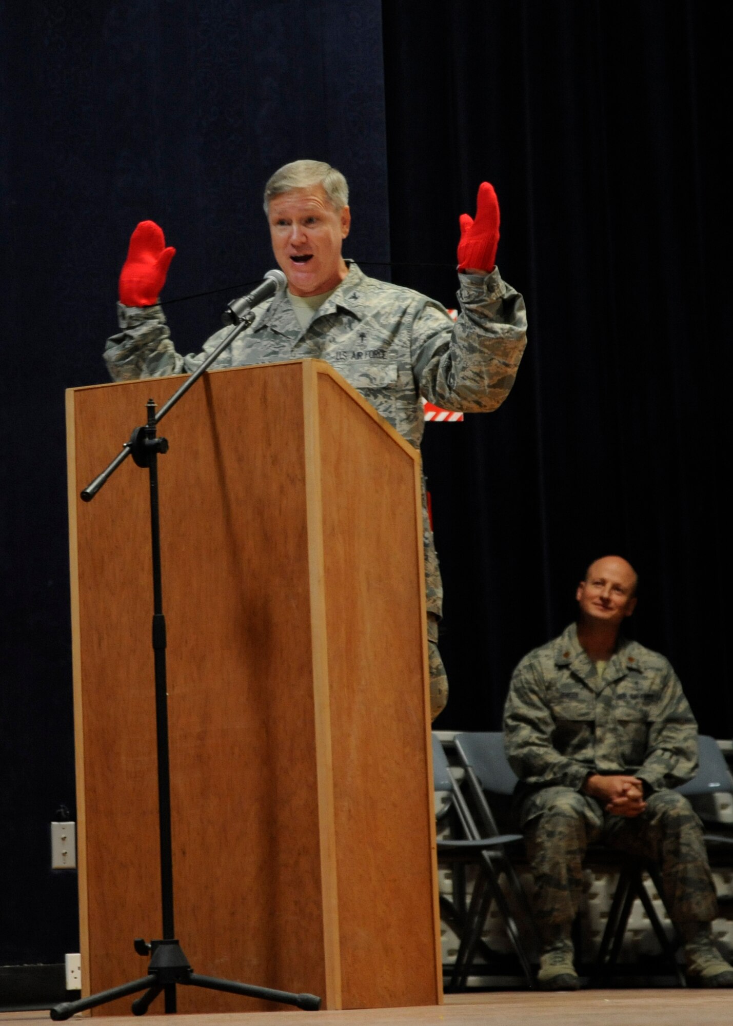 Chaplain (Col.) Steve Keith delivers a Thanksgiving message during the Interfaith Thanksgiving service at the 379th Air Expeditionary Wing in Southwest Asia, Nov. 28, 2013. The red gloves were from an anecdote he shared about his childhood, reminding attendees to be thankful. Keith is the 379th AEW wing chaplain deployed from Fort Jackson, S.C., and a Flint, Mich., native. (U.S. Air Force photo/Senior Airman Bahja J. Jones) 
