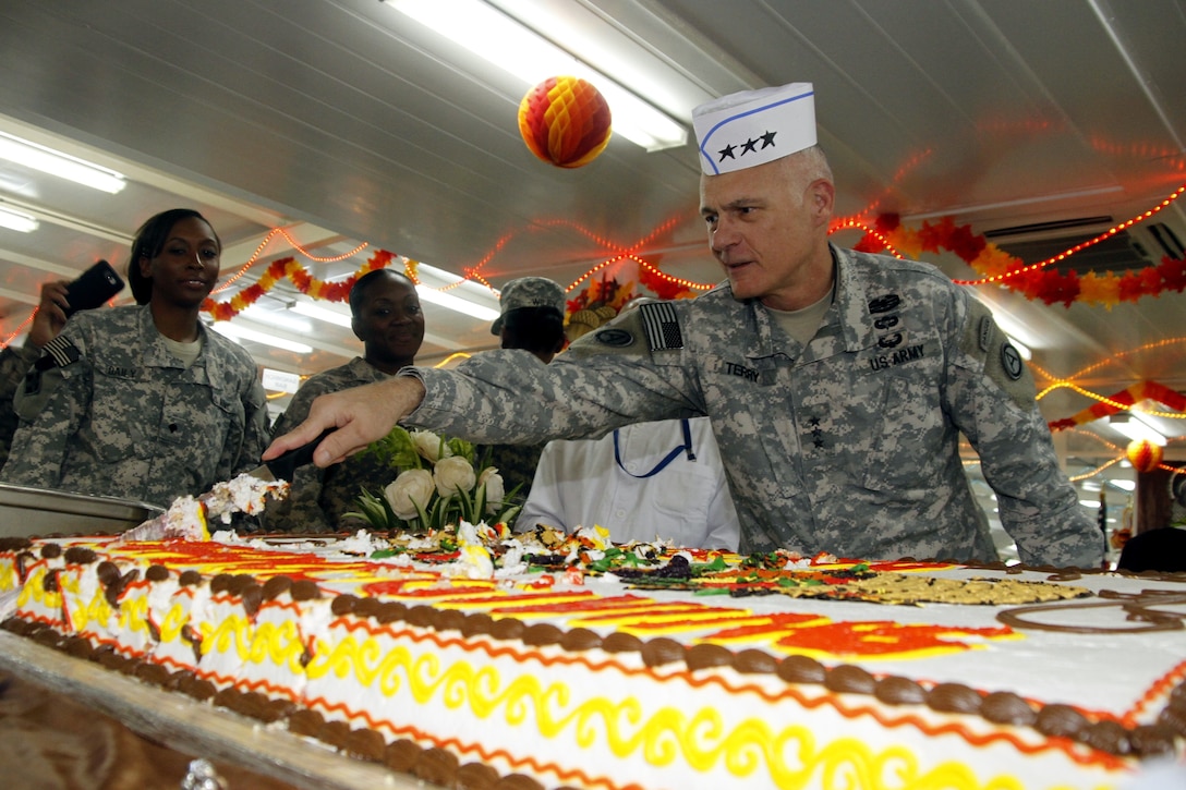 U.S. Army Lt. Gen. James L. Terry, commanding general of U.S. Army Central Command, cuts a cake for soldiers during Thanksgiving Day lunch on Camp Buehring in Kuwait, Nov. 28, 2013. The soldiers, assigned to the 36th Combat Aviation Brigade, are deployed to the Middle East to support Operation Enduring Freedom.