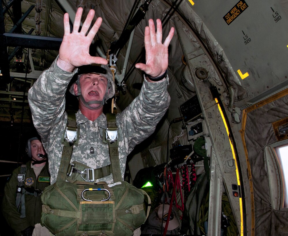 Army Master Sgt. Raymond Geoghegan gives the 10-minute time warning to paratroopers as they approach Luzon Drop Zone and prepare to conduct airborne training on Fort Bragg, N.C., Nov. 21, 2013. Geoghegan is a jumpmaster assigned to the 82nd Airborne Division's 782nd Brigade, Support Battalion.