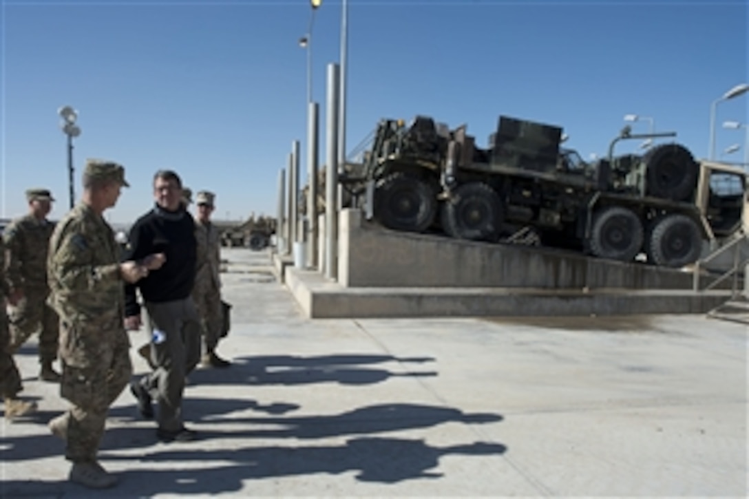 U.S. Deputy Defense Secretary Ash Carter walks with U.S. Army Lt. Col. Roy W. Speaks at the retrograde facility on Kandahar Airfield, Afghanistan, Nov. 29, 2013. Carter visited with troops who are moving military equipment out of Afghanistan during the drawdown. Speaks commands the Army Field Support Battalion Kandahar, 401st Army Field Support Brigade.