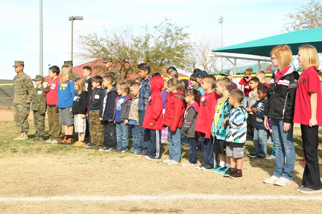 Children aboard the Combat Center practice Marine Corps drill and ceremony during a mock combined-arms exercise for kids at Felix Field Nov. 26, 2013.