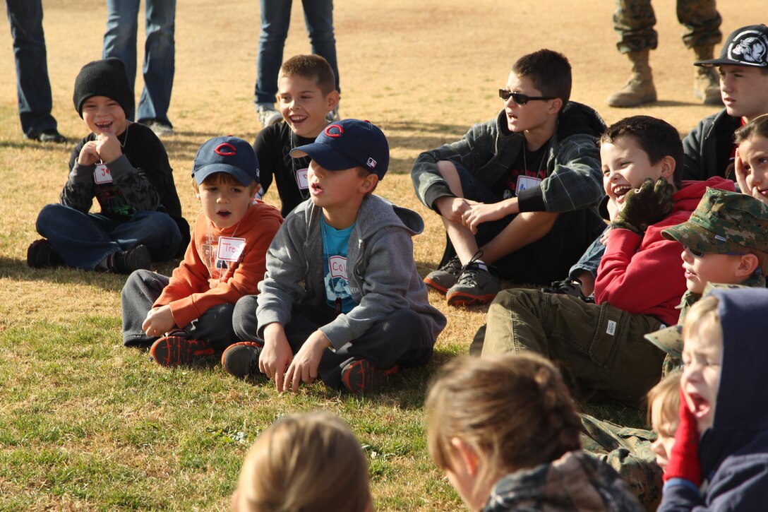 Children aboard the Combat Center listen as Staff Sgt. Arold Sylvain, motor transport operations chief, Unmanned Aerial Vehicle Squadron 3, instructs them on Marine Corps drill and ceremony during a mock combined-arms exercise for kids at Felix Field Nov. 26, 2013.
