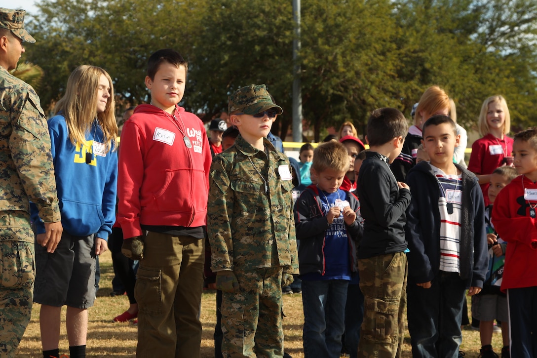 Children aboard the Combat Center practice Marine Corps drill and ceremony during a mock combined-arms exercise for kids at Felix Field Nov. 26, 2013.