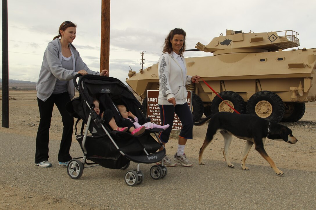 Amanda Kendrick and Vera Savage, members of the Sweating Bullets fitness club, walk side by side along the Physical Fitness test track aboard the Combat Center Nov. 21, 2013