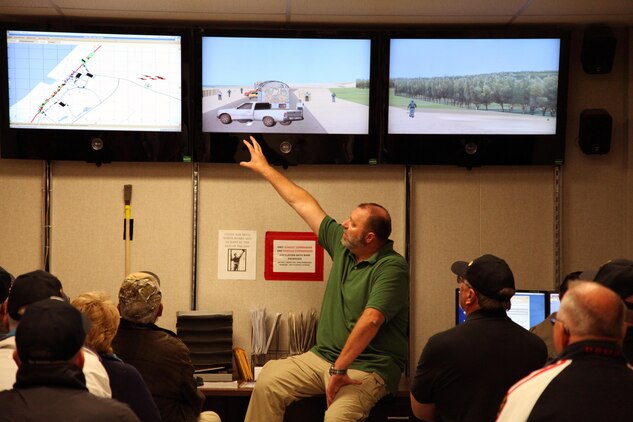 Tour guide Michael King explains to High Desert Marines tour participants how instructors create combat convoy scenarios at the Battle Simulation Center at Camp Wilson. The group of former and retired Marines from the Victor Valley toured the center Nov. 20, 2013.