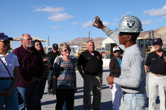 Members of the High Desert Marines organization from the Victor Valley listen as Range Sustainment Branch work leader Jay Jones shows off a shell casing that will be processed into brass pellets and sold as part of the Combat Center's range recycling program. In addition to paying workers and covering facility expenses, proceeds from the program are used to improve quality of life here and at the Marine Corps Mountain Warfare Training Center in Bridgeport. 