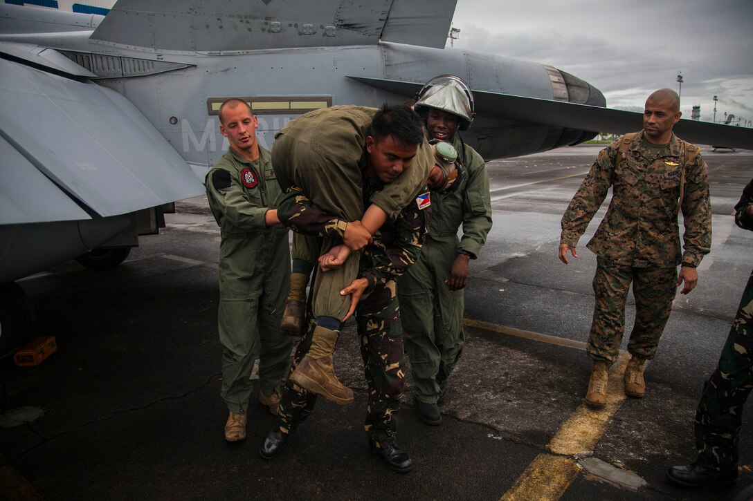 Philippine Air Force Airman 1st Class Villegas Ramwyl carries U.S. Marine Cpl. Abraham Bernado during aircraft rescue and firefighting training at Clark Air Field, Pampanga, Republic of the Philippines, Sept. 26 part of Amphibious Landing Exercise 2014. The day of training familiarized the Armed Forces of the Philippines members with egress procedures should an aircraft mishap occur. The Philippine and U.S. militaries often engage in bilateral training in the common interest of regional security. Bernado is power line mechanic with Marine Wing Support Squadron 172, Marine Wing Support Group 17, 1st Marine Aircraft Wing, III Marine Expeditionary Force.