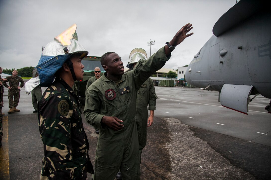 U.S. Marine Sgt. Devon McIntyre explains the fundamentals of aircraft rescue and firefighting training at Clark Air Field, Pampanga, Republic of the Philippines, Sept. 26 during Amphibious Landing Exercise 2014. The day of training familiarized the Armed Forces of the Philippine members with egress procedures should an aircraft mishap incident occur. PHIBLEX 14 is an annual, bilateral training exercise focused on enhancing security and stability within the region. McIntyre is the ARFF training noncommissioned officer-in-charge with Marine Wing Support Squadron 172, Marine Wing Support Group 17, 1st Marine Aircraft Wing. 