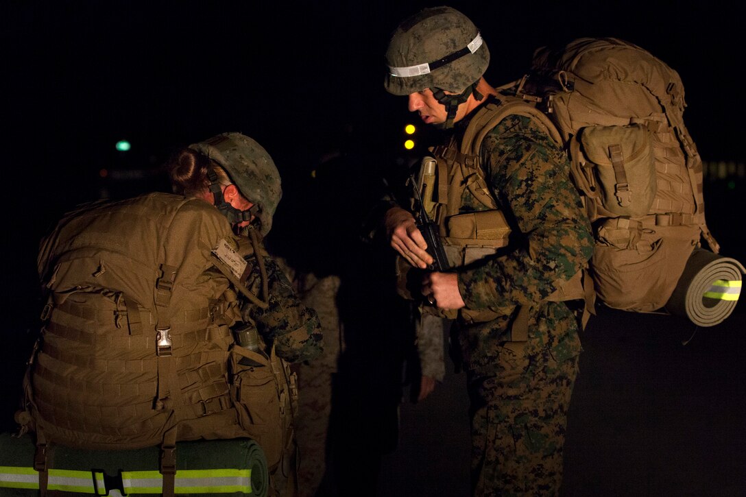 A combat instructor at the Infantry Training Battalion observes as a female student removes her pack after failing to keep up with the other students on a 5-kilometer hike during the first week of training at Marine Corps Base Camp Geiger, N.C., Sept. 28, 2013. Students will be counseled for failing any of the first three hikes during their training, but must pass the 20-kilometer hike midway through the cycle to continue training. Fifteen female Marines were given the opportunity to attend the training after boot camp for the first time in Marine Corps history as part of ongoing research into the acceptance of women into combat-related job fields. The female Marines go through the same training and are held to the same ITB standards as their male counterparts. (U.S. Marine Corps photo by Cpl. Chelsea Flowers Anderson/Released)