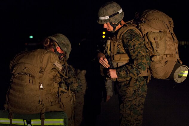 A combat instructor at the Infantry Training Battalion observes as a female student removes her pack after failing to keep up with the other students on a 5-kilometer hike during the first week of training at Marine Corps Base Camp Geiger, N.C., Sept. 28, 2013. Students will be counseled for failing any of the first three hikes during their training, but must pass the 20-kilometer hike midway through the cycle to continue training. Fifteen female Marines were given the opportunity to attend the training after boot camp for the first time in Marine Corps history as part of ongoing research into the acceptance of women into combat-related job fields. The female Marines go through the same training and are held to the same ITB standards as their male counterparts. (U.S. Marine Corps photo by Cpl. Chelsea Flowers Anderson/Released)