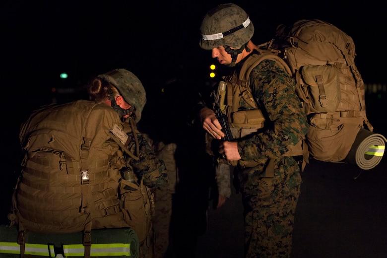 A combat instructor at the Infantry Training Battalion observes as a female student removes her pack after failing to keep up with the other students on a 5-kilometer hike during the first week of training at Marine Corps Base Camp Geiger, N.C., Sept. 28, 2013. Students will be counseled for failing any of the first three hikes during their training, but must pass the 20-kilometer hike midway through the cycle to continue training. Fifteen female Marines were given the opportunity to attend the training after boot camp for the first time in Marine Corps history as part of ongoing research into the acceptance of women into combat-related job fields. The female Marines go through the same training and are held to the same ITB standards as their male counterparts. (U.S. Marine Corps photo by Cpl. Chelsea Flowers Anderson/Released)