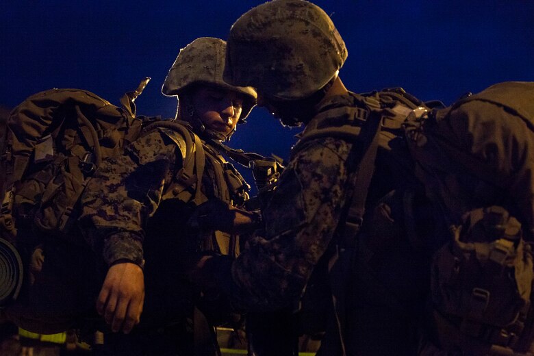 A student with Infantry Training Battalion helps another student with his pack following a 5-kilometer hike during the first week of training at Marine Corps Base Camp Geiger, N.C., Sept. 28, 2013. The students will complete 10-kilometer, 15-kilometer and 20-kilometer hikes throughout their training iteration. Fifteen female Marines were given the opportunity to attend the training after boot camp for the first time in Marine Corps history as part of ongoing research into the acceptance of women into combat-related job fields. The female Marines go through the same training and are held to the same ITB standards as their male counterparts. (U.S. Marine Corps photo by Cpl. Chelsea Flowers Anderson/Released)
