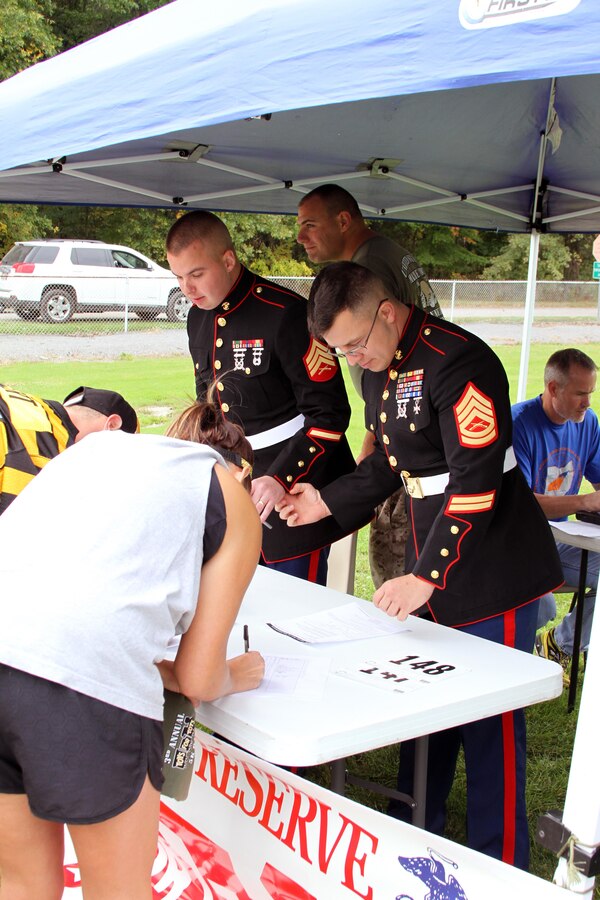 U.S. Marine Corps Sgt. Jesse Sherman of Bainbridge, N.Y., and GySgt. Joseph Zufelt from Victorville, Calif., both with Detachment 3 Maintenance Company, Combat Logistics Battalion 453, help runners register for the 3rd Annual Toys for Tots 5K run held at Imagination Station Park in Cortland, Ohio, Sept. 29, 2013. The 5K raised money for the Toys for Tots program which helps communities by giving toys to children on Christmas who may not have any other means to get one. (U.S. Marine Corps photo by Sgt. T.M. Stewman/Released)