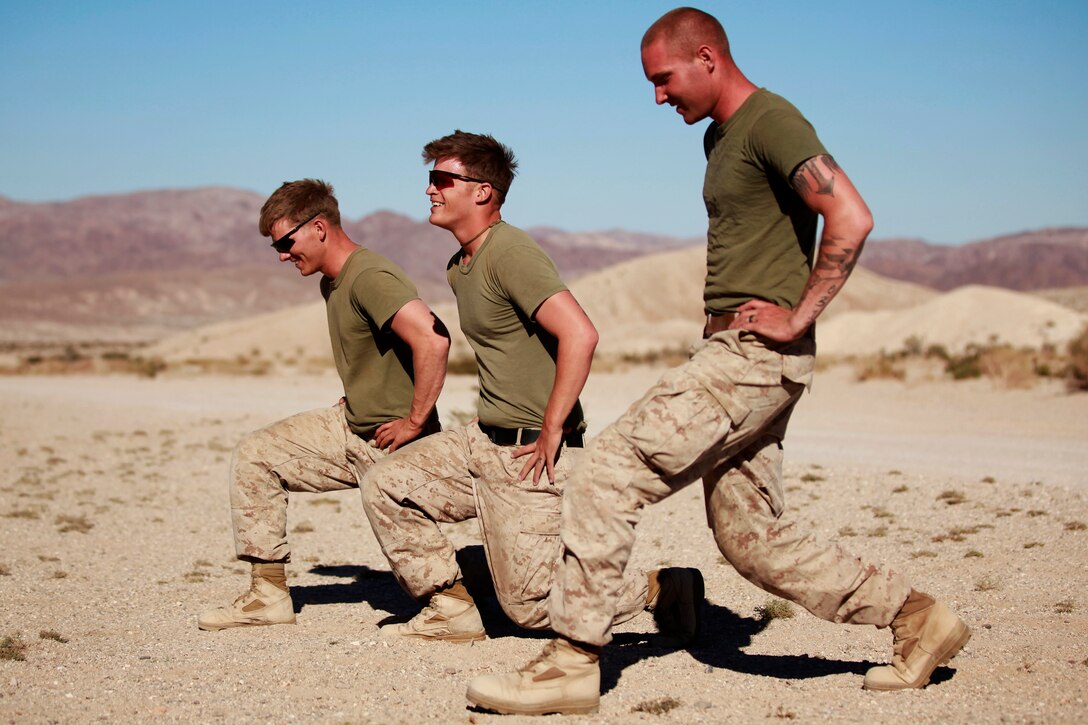 Marines with Fox Company, 2nd Battalion, 3rd Marine Regiment, perform lunges during physical training while resting between training exercises in the desert. The unit is conducting the Integrated Training Exercise at the Marine Corps Air Ground Combat Center Twentynine Palms, Calif., Sept. 17, 2013. (U.S. Marine Corps photo by Cpl. Sarah Dietz)