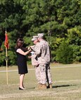 Incoming commanding officer Navy Capt. Michael Sokolowski’s wife Kathleen pins on the command pin to his blouse during a change of command ceremony aboard Camp Lejeune, N.C. Sept. 30, 2013. Sokolowski was most recently stationed in Naples, Italy, where he fulfilled many billets, such as the senior medical planner. (U.S. Marine Corps photo by Lance Cpl. Shawn Valosin)