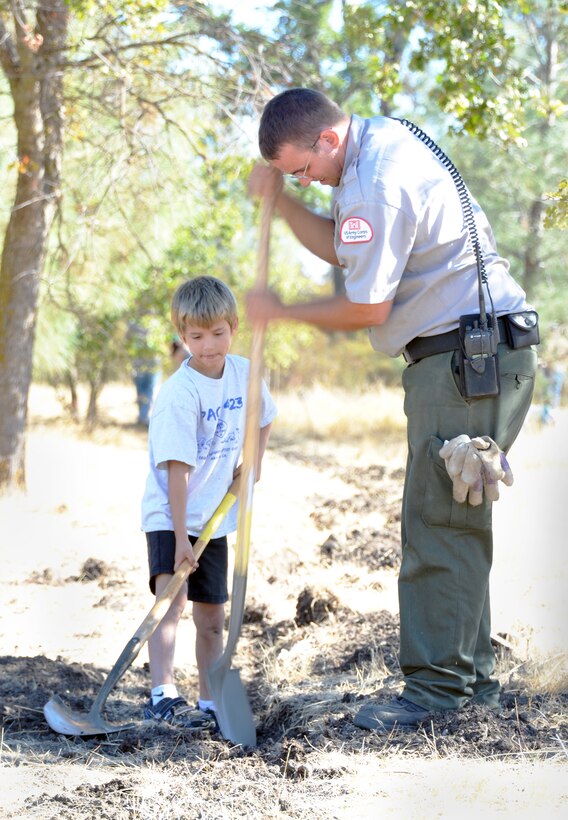 Park ranger Trevor Wagner works alongside a Cub Scout from Pack 423 of Manteca during National Public Lands Day, Sept. 28, 2013, at New Hogan Lake, the U.S. Army Corps of Engineers Sacramento District park near Valley Springs, Calif. (U.S. Army photo by Robert Kidd/Released)