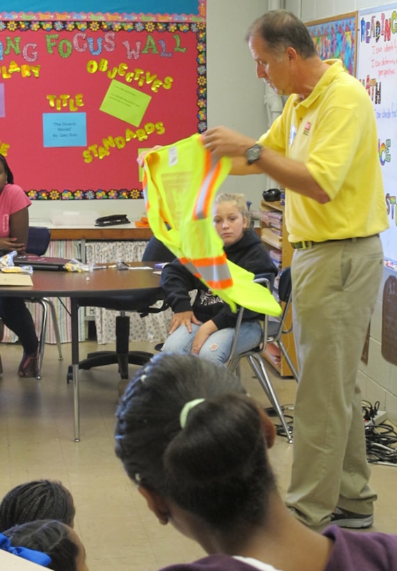 Pat Haas, Huntsville Center engineer and Director of Chemical Demilitarization Directorate, shows students how engineers use safety equipment in a field environment during Career Day Sept. 27.