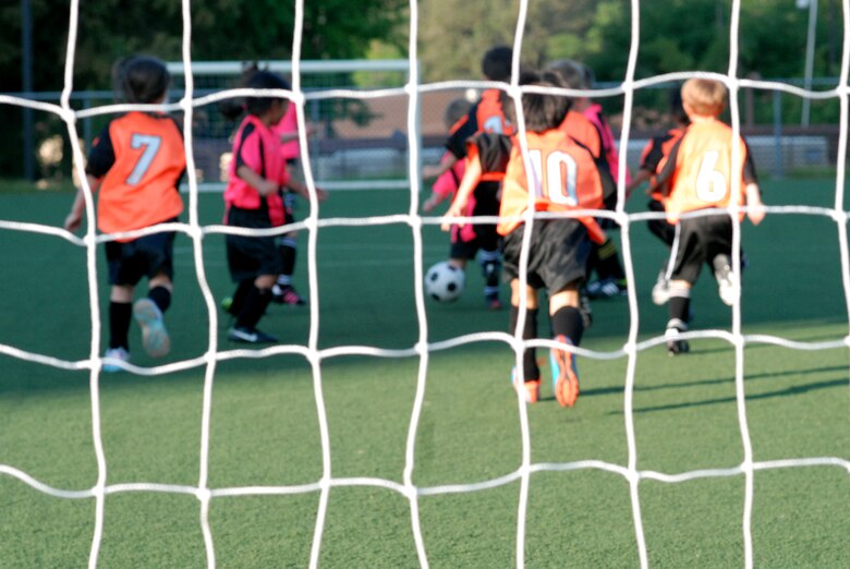 Players from the age 5-6 division of youth soccer play a season game at Osan Air Base, Republic of Korea, Sept. 25, 2013. Players from the Dragons (orange) team played their first match against the Crushers (pink), who played their second match this season. Youth sports are made possible by dedicated volunteer coaches from the base community. If interested in volunteering for seasonal youth sports, contact the director of youth sports by emailing matthew.sharman@us.af.mil. (U.S. Air Force photo/1st Lt. Kay M. Nissen)