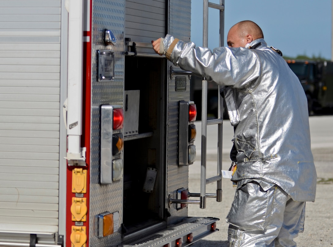 Airman 1st Class Robert Butler, 36th Civil Engineer Squadron Fire and Emergency Services firefighter, checks the availability of equipment during the annual multi-agency fuel spill response training event Sept. 26, 2013, at the 36th Logistics Squadron Fuels Management Flight compound on Andersen Air Force Base, Guam. Airmen and civilians responded with fire trucks, patrol cars, an ambulance and equipment needed to assess, contain and clean up the simulated 10,000-gallon fuel spill. (U.S. Air Force photo by Senior Airman Marianique Santos/Released)