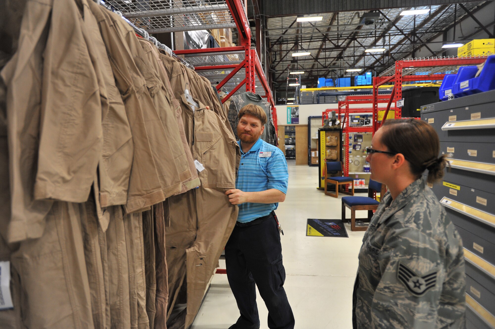 Eric Fornoff, Envision cashier, assists Staff Sgt. Cassie Kennedy, 242nd Combat Communications Squadron supply traditional, at the Base Supply Store at Fairchild Air Force Base, Wash., Sept. 30, 2013. Fornoff is legally blind and has been working on Fairchild for eight years. (U.S. Air Force photo by Staff Sgt. Veronica Montes/Released)
