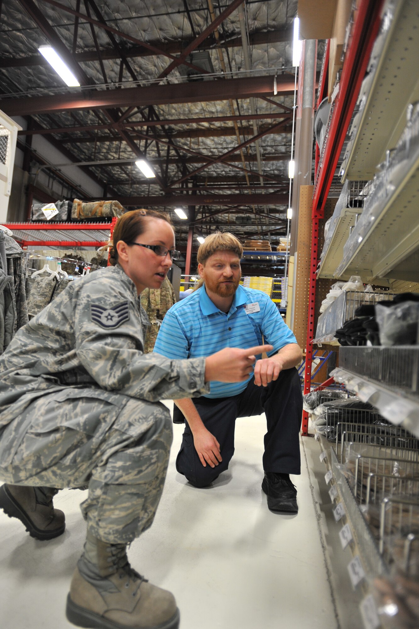 Eric Fornoff, Envision cashier, assists Staff Sgt. Cassie Kennedy, 242nd Combat Communications Squadron supply traditional, at the Base Supply Store at Fairchild Air Force Base, Wash., Sept. 30, 2013. Fornoff is legally blind and has been working on Fairchild for eight years. (U.S. Air Force photo by Staff Sgt. Veronica Montes/Released)