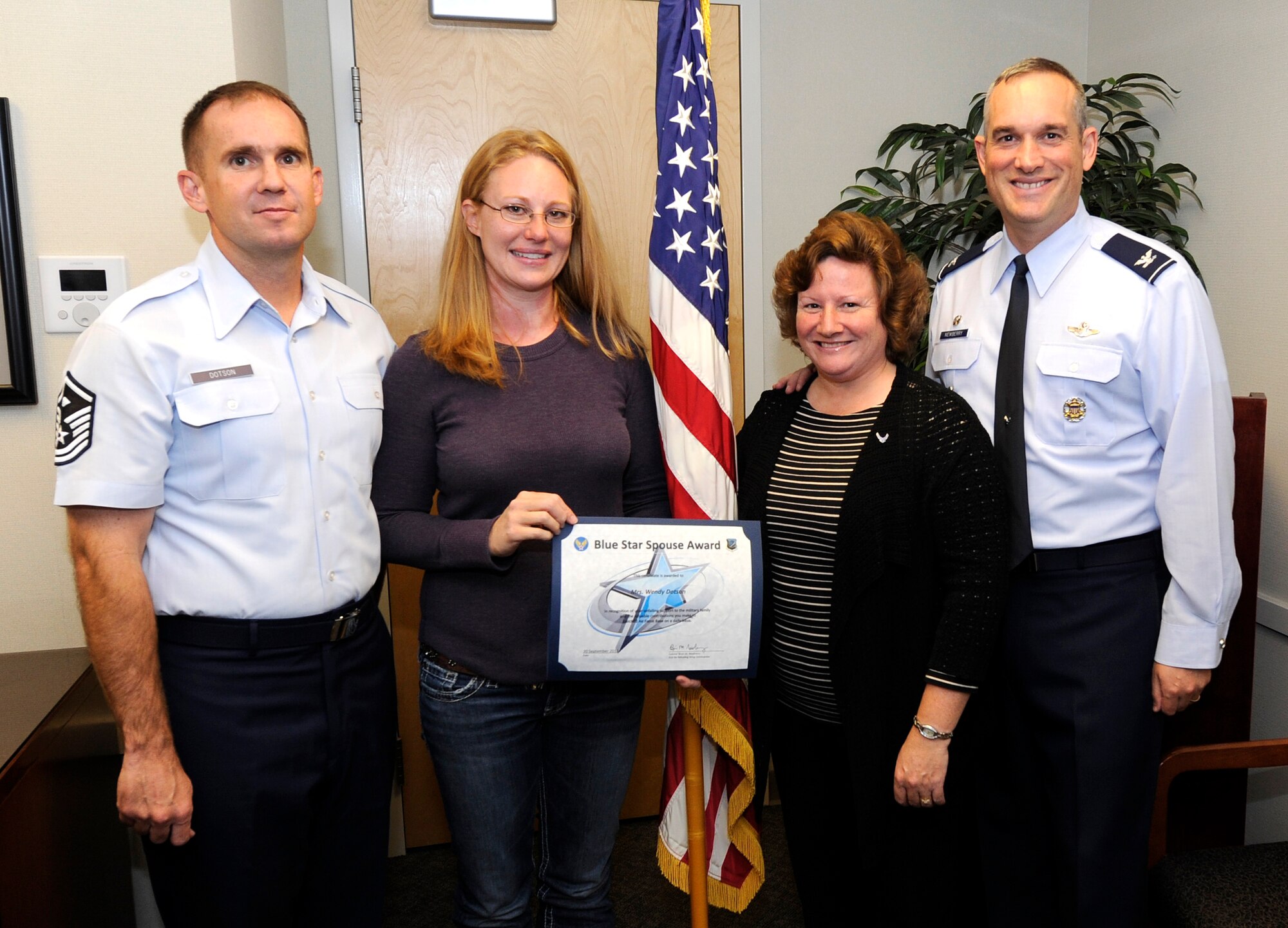 Col. Brian Newberry, 92nd Air Refueling Wing commander, and his wife, Jill, present the Blue Star Spouse Award to Wendy Dotson, Sept. 30, 2013. The award is presented to Fairchild spouses for their commitment to excellence and support to the Fairchild family. Dotson is an active member of the enlisted spouses club. Her selfless contributions to the 92nd Operation Support Squadron have been appreciated. Anyone interested in nominating someone for the Blue Star Spouse Award should contact their squadron commander. (U.S. Air Force photo by Airman 1st Class Ryan Zeski/Released) 