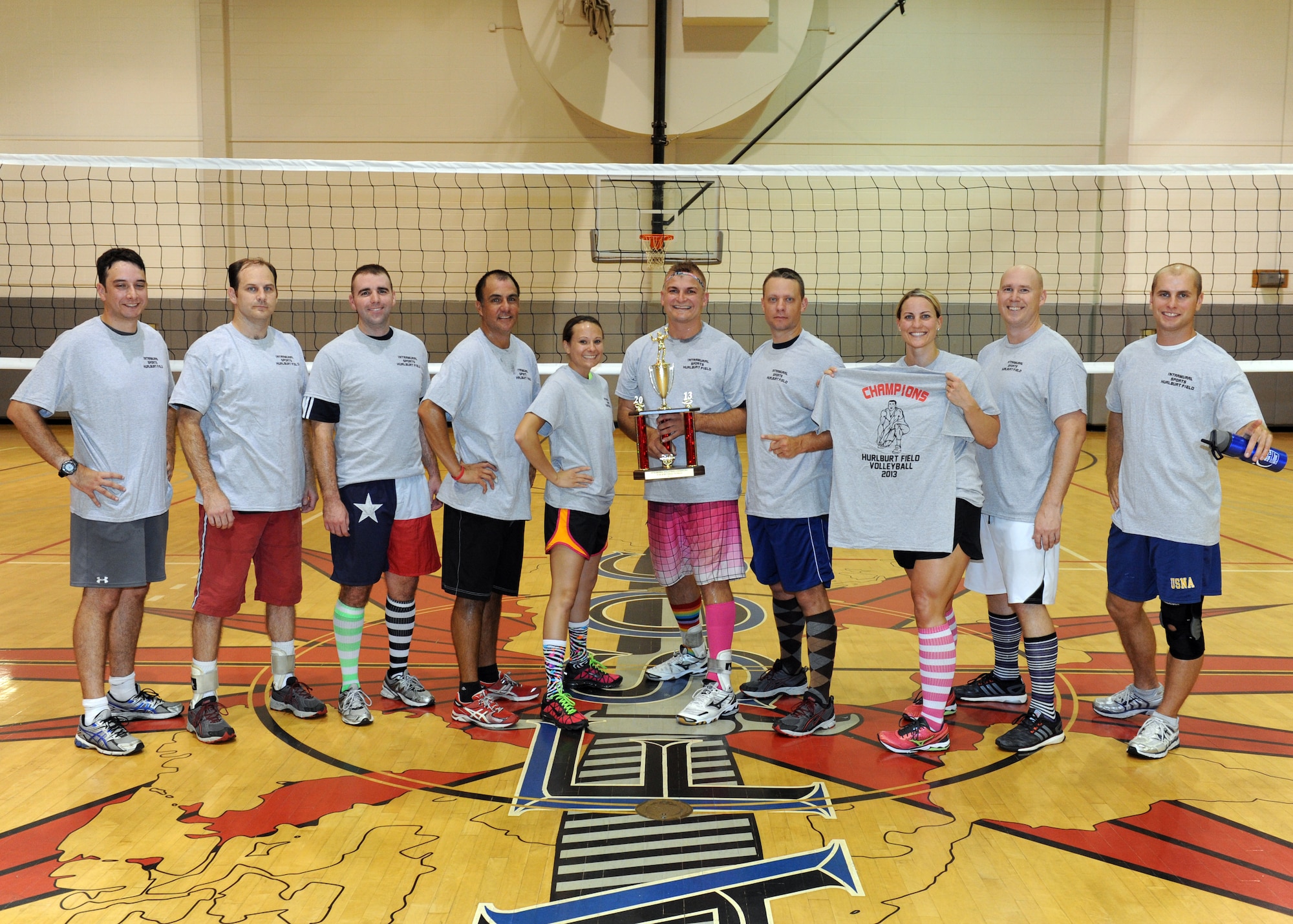 The 19th Special Operations Squadron volleyball team stands with bright socks and a championship trophy at the conclusion of the Hurlburt Field Intramural Volleyball Tournament Sept. 20, 2013, at Hurlburt Field, Fla. “It was the socks” which motivated them to victory, said Stephen Lanzola, 19th SOS captain. (U.S. Air Force photo/ Senior Airman Kentavist P. Brackin)