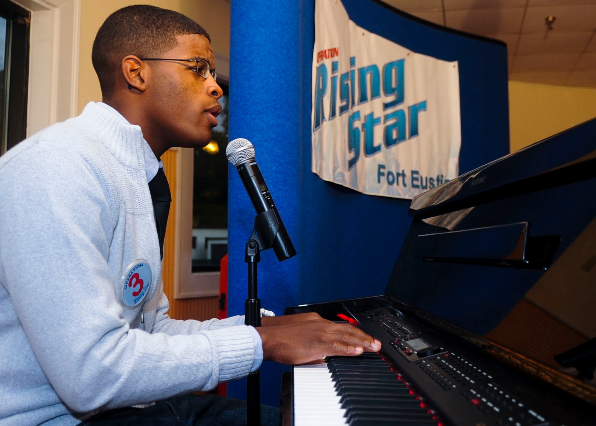 U.S. Army Pvt. Michah Colbert, an Advanced Individual Training student, performs during the Operation Rising Star competition at Fort Eustis, Va., Sept. 27, 2013. Contestants could play instruments, use props and move around the room during their performances. (U.S. Air Force photo by Airman 1st Class Austin Harvill)