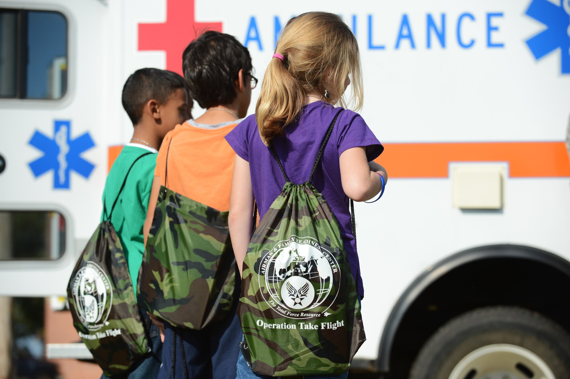 Children stand outside an ambulance during Operation Take Flight  at Shaw Air Force Base, S.C., Sept. 26, 2013. Operation Take Flight is a deployment-simulation event that showcased various gear, weapons, vehicles and jobs in a fun manner for children. It was held to give children an idea of what the Air Force does, and what their parents go through when deploying. (U.S. Air Force photo by Airman 1st Class Daniel Blackwell/Released)
