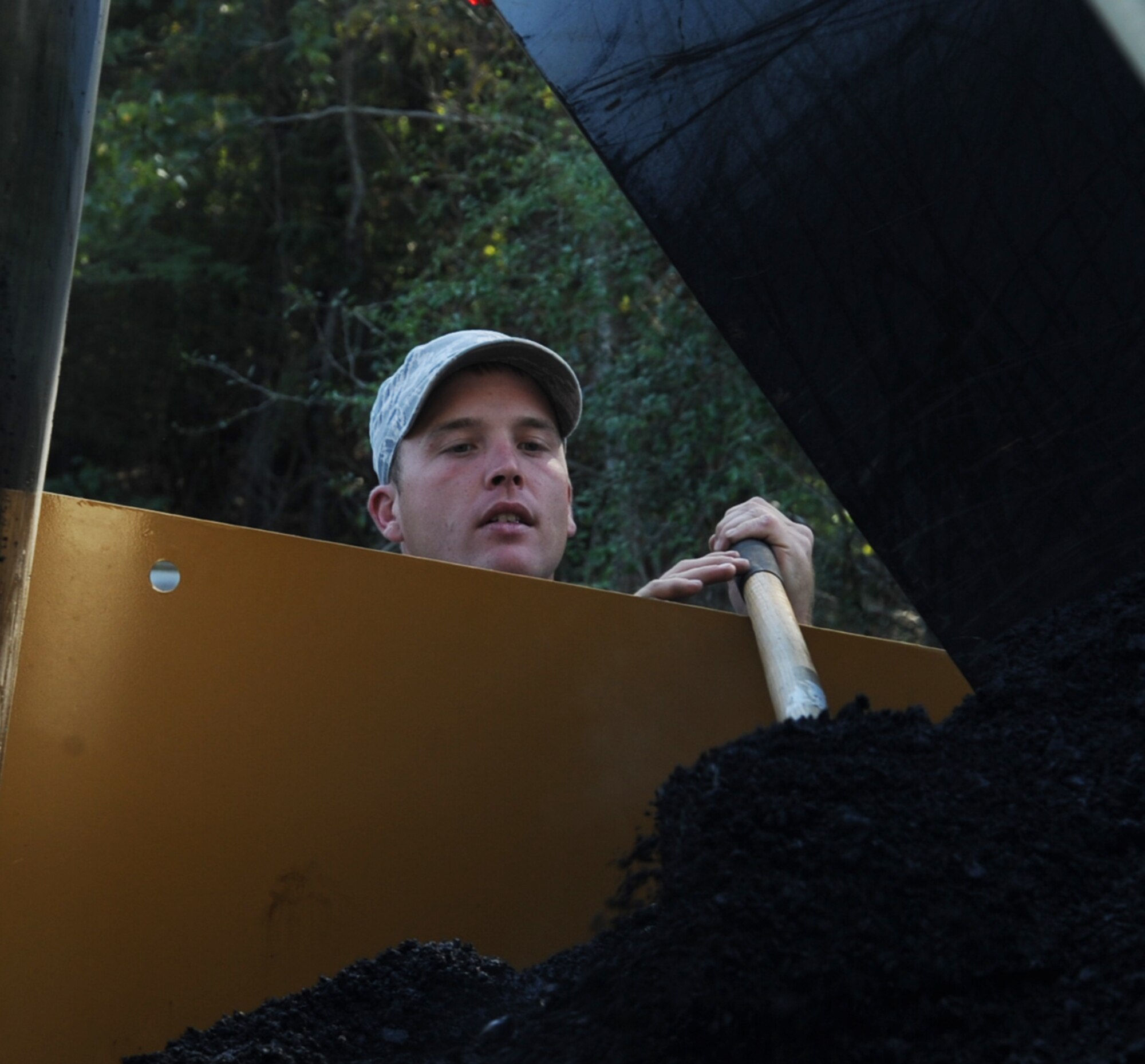 Senior Airman Timothy Jechort, 2nd Civil Engineer Squadron paving and equipment journeyman, monitors the flow of asphalt during construction at the Bodcau gate on Barksdale Air Force Base, La., Sept. 27, 2013. For the road construction, CE Airmen used 60 tons of asphalt over a 200 square feet area. (U.S. Air Force photo/Senior Airman Sean Martin)
