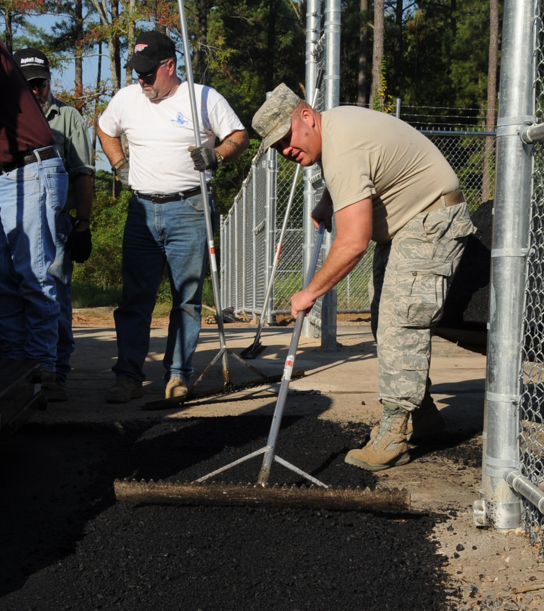 Master Sgt. Michael Stout, 2nd Civil Engineer Squadron paving and equipment NCO in-charge, smoothes a piece of road during construction at the Bodcau gate on Barksdale Air Force Base, La., Sept. 27, 2013. The 2nd CES portion of the gate construction included building an access to the base perimeter fence for the 2nd Security Forces Squadron, placing a semi-permanent guard shack and paving two traffic lanes. (U.S. Air Force photo/Senior Airman Sean Martin)
