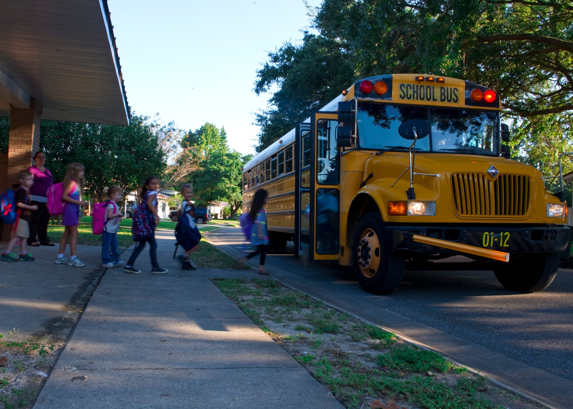 Children board a school bus in Hurlburt Field housing, Oct. 1, 2013. There are several bus stops throughout base transporting more than 500 children who reside in housing, to and from school. (U.S. Air Force Photo/Staff Sgt. John Bainter)