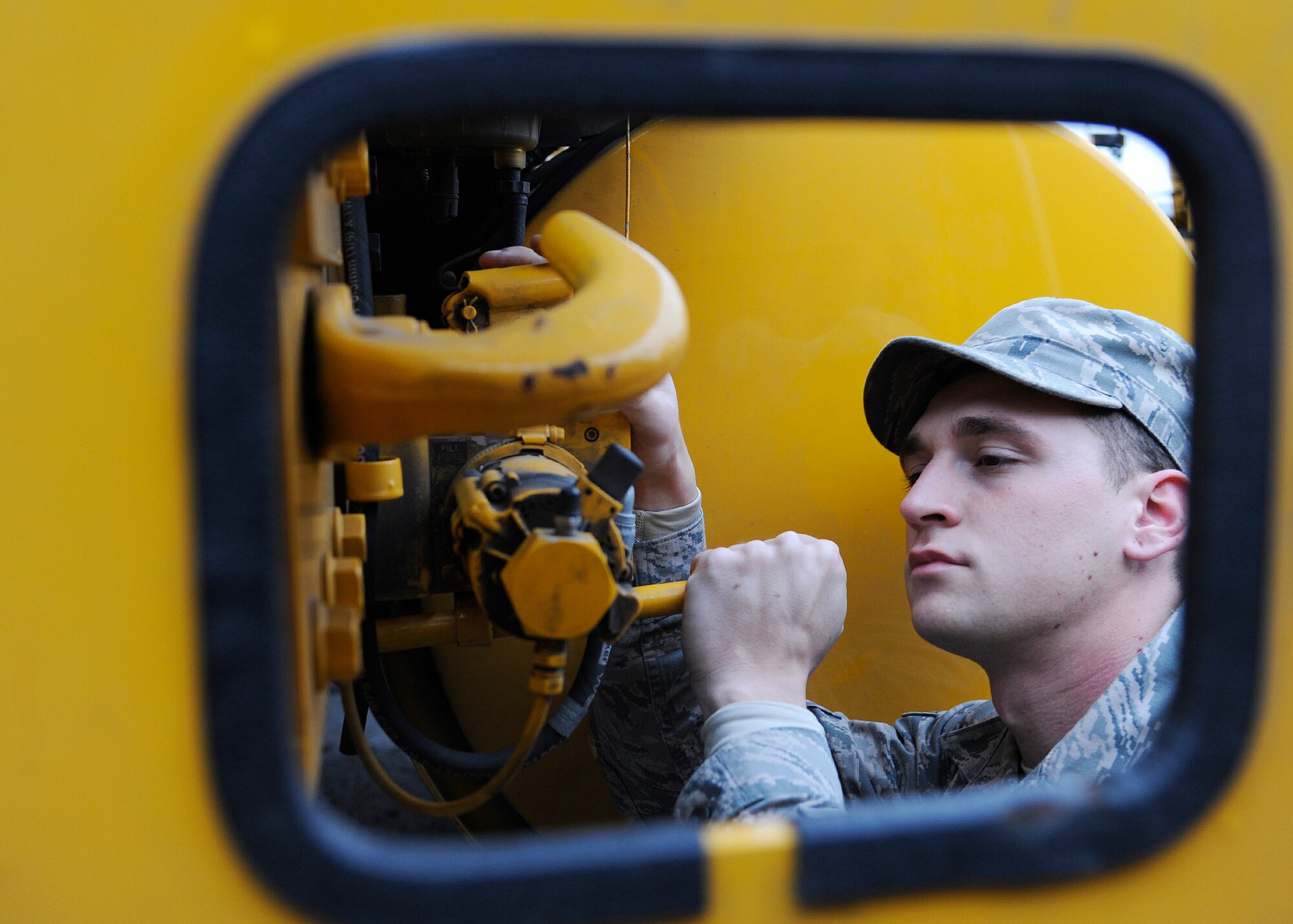 Airman 1st Class David Cline, 354th Civil Engineer Squadron heavy equipment operator, raises the rear cab on a snow plow during a preventive maintenance check during Snow School Sept. 26, 2013, Eielson Air Force Base, Alaska. Thirty-five Airmen attended the week-long course, which trained them on driving and maintaining different equipment needed for the upcoming winter season. (U.S. Air Force photo by Senior Airman Ashley Nicole Taylor/Released) 