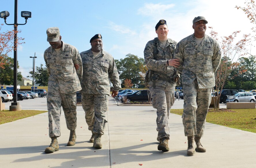U.S. Air Force Master Sgt. Robert Palmer, 20th Security Forces Squadron training NCO in charge, and Staff Sgt. Brian Zarrella, 20th SFS patrolman, escort Senior Master Sgt. Damon Pettaway, 20th SFS first sergeant, and Chief Master Sgt. James Wilkerson, 20th Fighter Wing command chief, during the SFS Jail and Bail fundraiser, Shaw Air Force Base, S.C., Sept. 26, 2013. 20th SFS held a base wide Jail and Bail fundraiser for the Defender's Association, during which they handcuffed 57 Airmen and Soldiers and raised $1,464. (U.S. Air Force photo by Senior Airman Tabatha Zarrella/Released)
