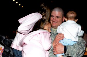 U.S. Air Force Staff Sgt. Kenneth Taiclet, 633rd Communications Squadron client systems technician, embraces his children after surprising them at Busch Gardens in Williamsburg, Va., Sept. 28, 2013, when he returned one week early from his year-long deployment. After months of careful planning with his wife, Melissa, and the park’s staff, Taiclet set the stage for his surprise to take place during a Halloween-themed performance at the park. (U.S. Air Force photo by Airman 1st Class R. Alex Durbin/Released)