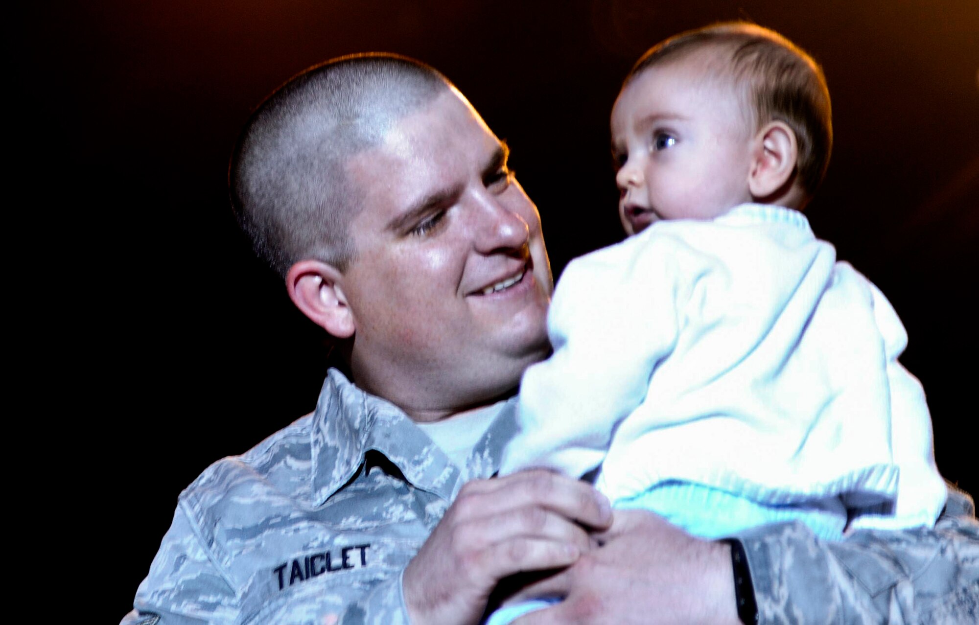 U.S. Air Force Staff Sgt. Kenneth Taiclet, 633rd Communications Squadron client system technician, holds his son, Nathaniel, for the first time since his birth in April after surprising his children at Busch Gardens in Williamsburg, Va., Sept. 28, 2013. Taiclet returned one week early from a year-long deployment giving his children a memory they will never forget. (U.S. Air Force photo by Airman 1st Class R. Alex Durbin/Released)