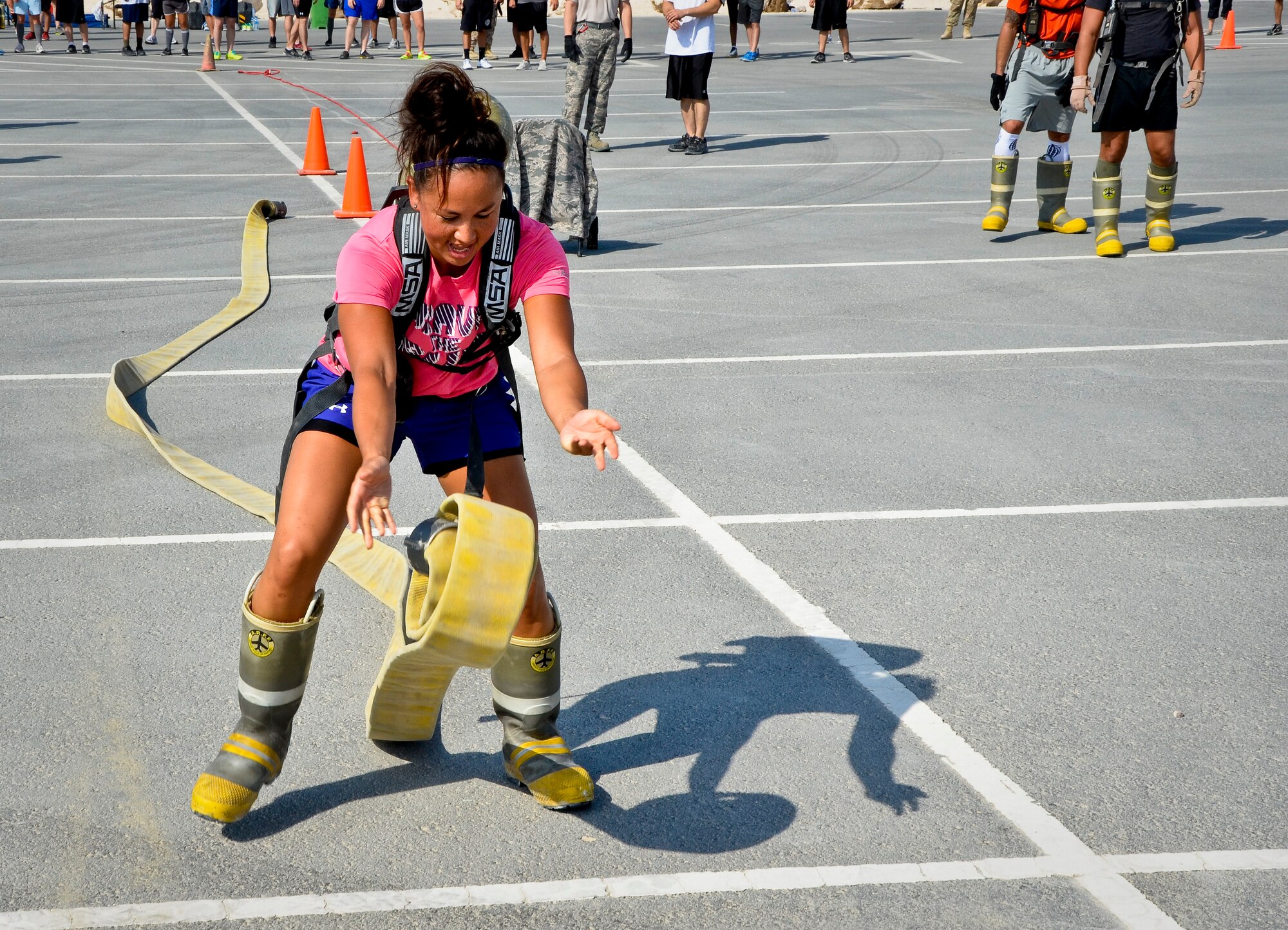 1st Lt. Sharon Kroening rolls out a hose reel during a relay race as part of a fire muster event at the 379th Air Expeditionary Wing in Southwest Asia, Sept. 28, 2013. Kroening is deployed from Robins Air Force Base, Ga., and hails from Osan Air Base, South Korea. (U.S. Air Force photo/Staff Sgt. Benjamin W. Stratton)