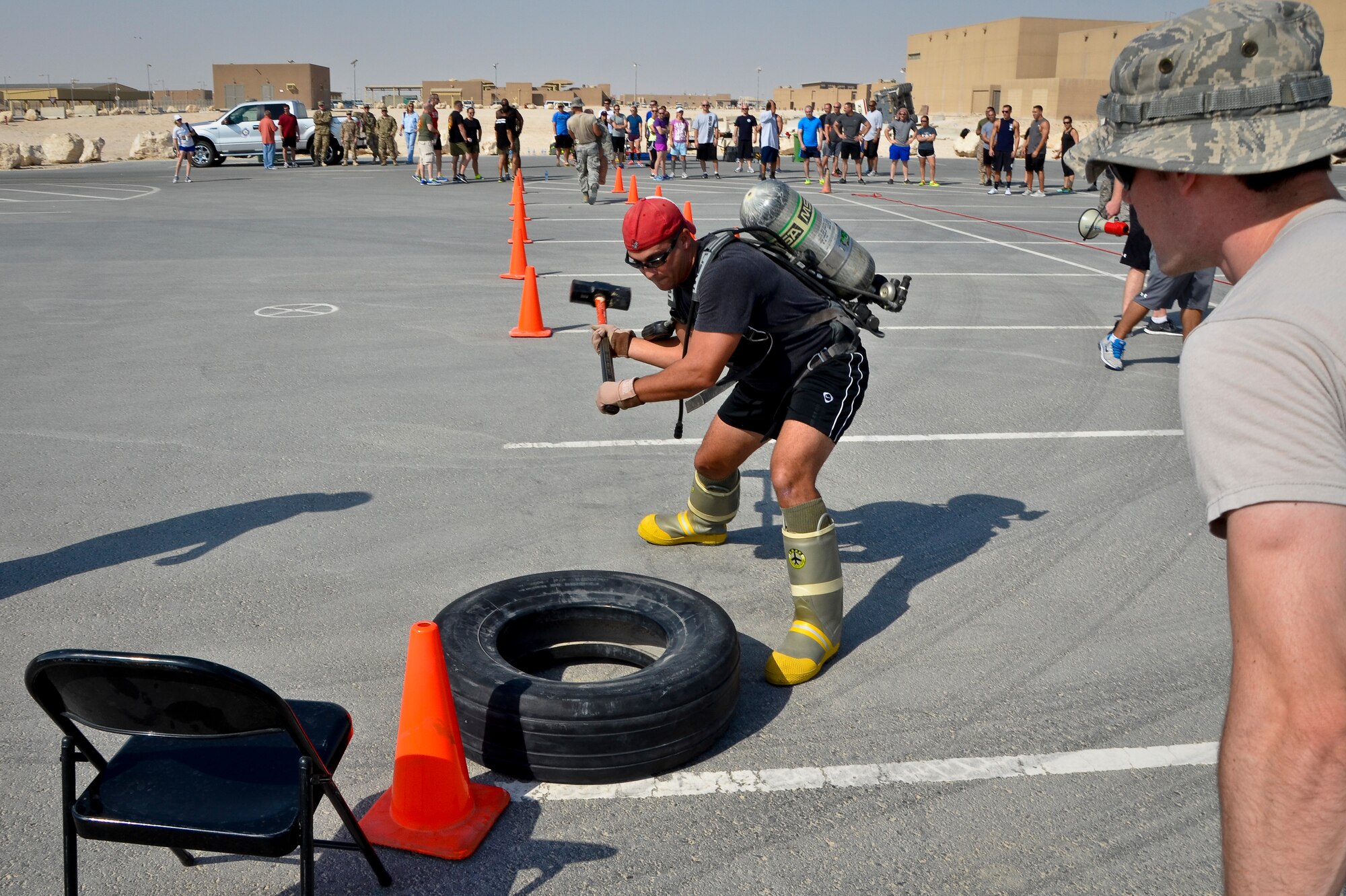 Tech. Sgt. Derek Woodard smacks a tire with a sledgehammer during a relay race as part of a fire muster event at the 379th Air Expeditionary Wing in Southwest Asia, Sept. 28, 2013. Woodard is deployed from Robins Air Force Base, Ga., and a Forsyth, Ga., native. (U.S. Air Force photo/Staff Sgt. Benjamin W. Stratton)