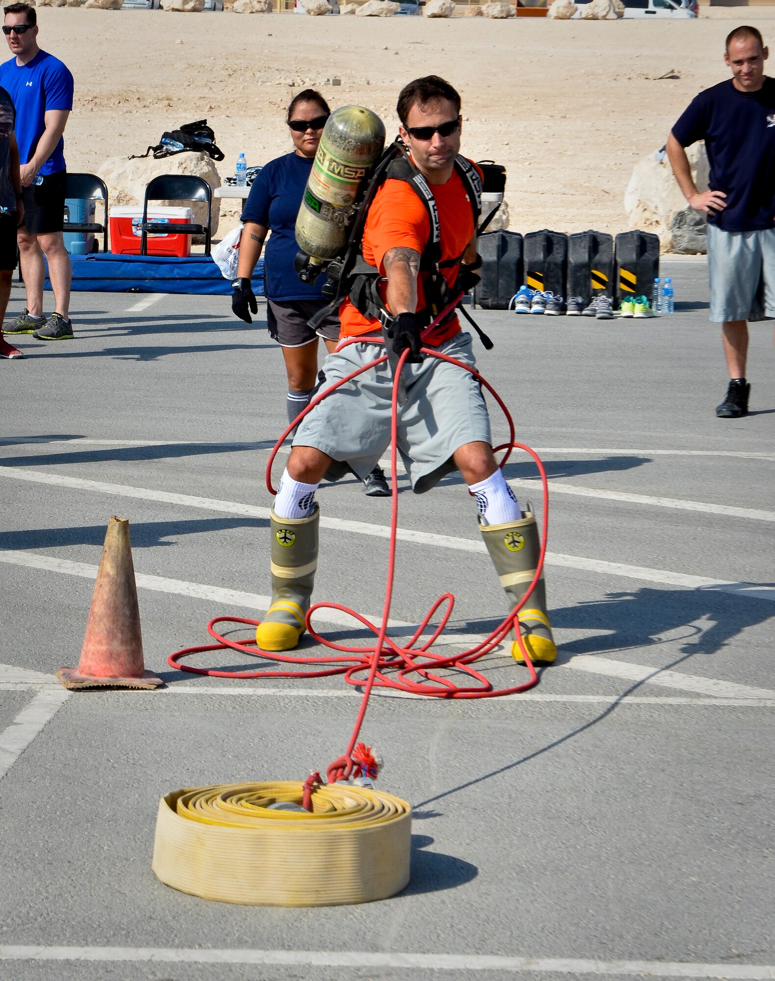 1st Lt. Ben Hosbein pulls a hose reel during a relay race as part of a fire muster event at the 379th Air Expeditionary Wing in Southwest Asia, Sept. 28, 2013. Hosbein is deployed from Robins Air Force Base, Ga., and a St. Joseph, Mich., native. (U.S. Air Force photo/Staff Sgt. Benjamin W. Stratton)