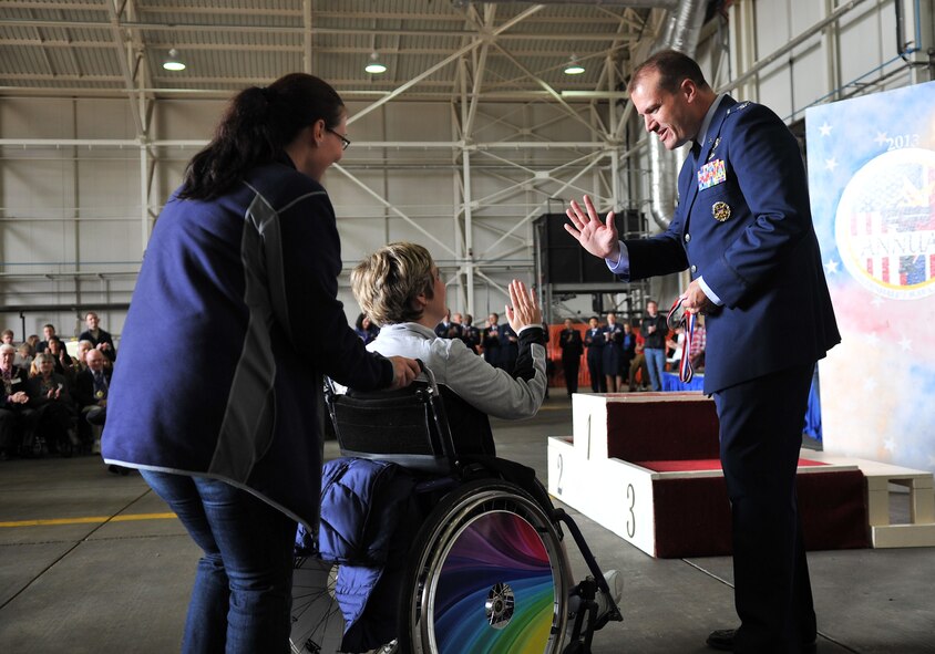U.S. Air Force Col. Kenneth T. Bibb Jr., 100th Air Refueling Wing commander, gives a high-five to an athlete Sept. 28, 2013, on RAF Mildenhall, England, during the 32nd annual Joan Mann Special Sports Day event. The sports day tradition began when Joan Mann, a Ministry of Defence employee who worked in the public affairs office on RAF Mildenhall, sought a way to bring the community together and work with special-needs citizens. (U.S. Air Force photo by Airman 1st Class Kyla Gifford/Released)