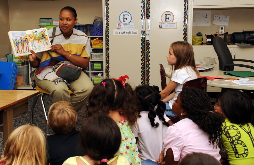 U.S. Air Force Staff Sgt. Joanna Gonzalez, 18th Force Support Squadron fitness specialist, reads a Spanish book to children while wearing a pancho during a three-day reading group at Bob Hope Primary School on Kadena Air Base, Japan, Oct. 1, 2013. Gonzalez was there to help educate and bring awareness of Hispanic Heritage Month which runs from Sept. 15 to Oct. 15. (U.S. Air Force photo by Naoto Anazawa)