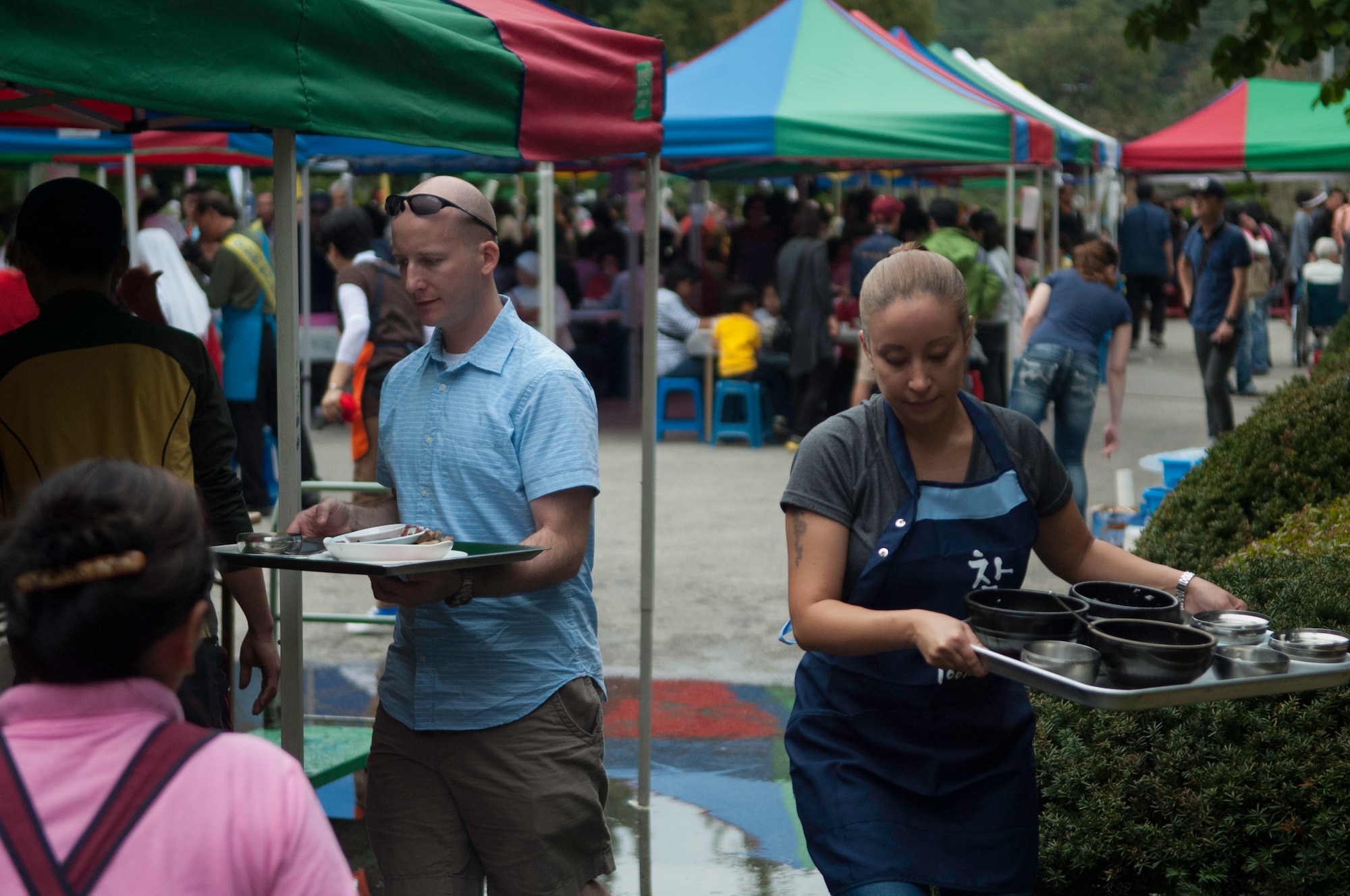 Major Ryan Chute, 8th Fighter Wing, left, and Master Sgt. Rosie Lopez, 8th Medical Group, right, bus tables at the Mount Saint Joseph Home for the Aged family day in Haewol-ri, Republic of Korea, Sept. 28, 2013. Airmen from the 8th FW voluteered throughout the day visiting with residents and families. Airmen also served food and helped clean up during the event. (U.S.  Air Force photo by Tech. Sgt. Alex Griffin/Released)