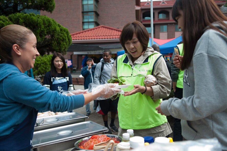 Master Sgt. Rosie Lopez, left, 8th Medical Group, hands out hamburgers to guests of the Mount Saint Joseph Home for the Aged Family Day in Haewol-ri, Republic of Korea, Sept. 28, 2013. Wolf Pack volunteers from the 8th Fighter Wing were there to visit with the residents and treat the group to a variety of American food. (U.S Air Force photo by Tech Sgt. Alex Griffin/Released)