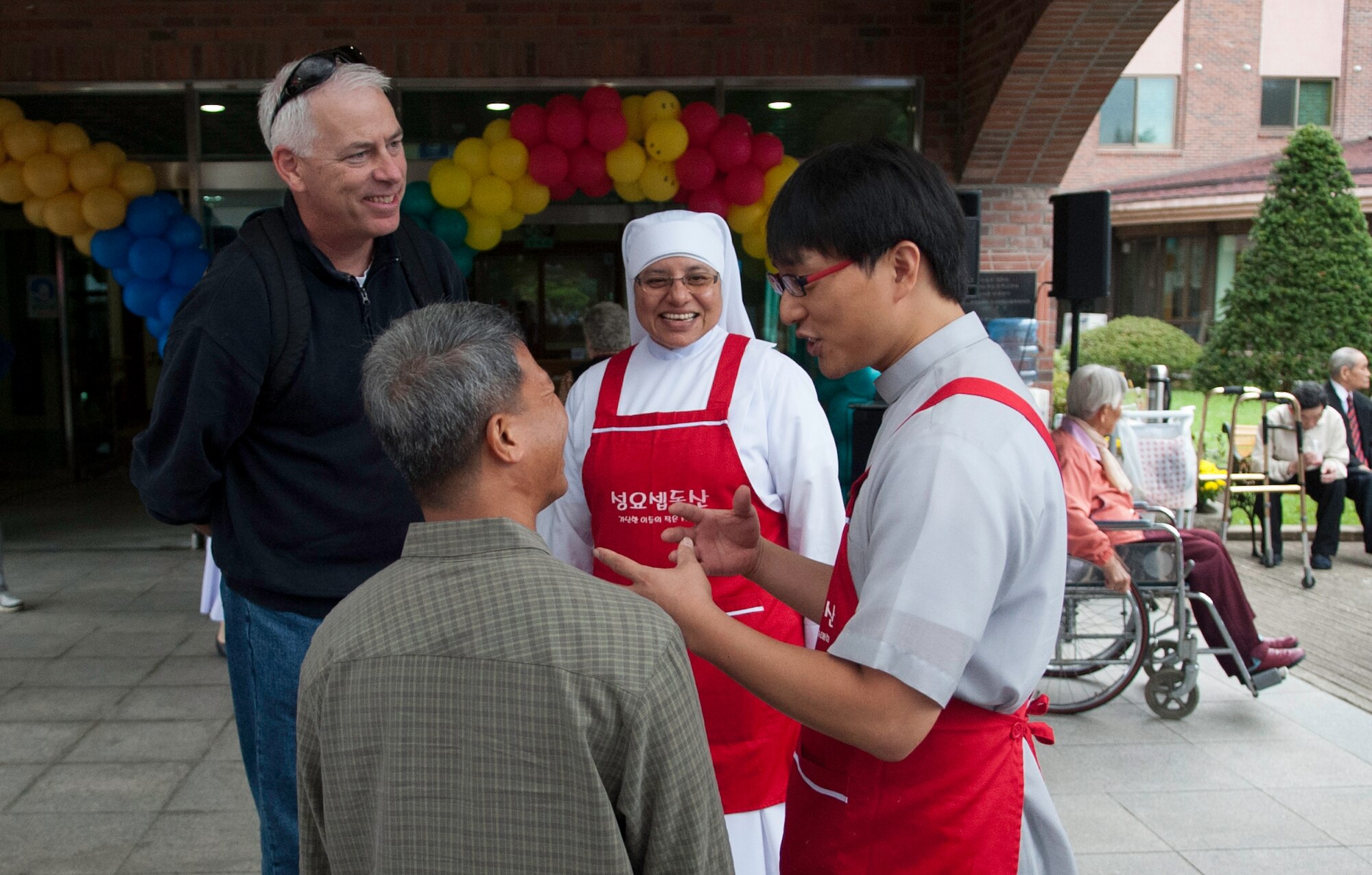 Eighth Fighter Wing Chaplain (Lt. Col.) Bryan Hochhalter, top left, and Chaplain (Capt.) Mario Rosario, 8th FW,  bottom left, talk with Sister Bernadette and Father John Choi during a Family Day at the Mount Saint Joseph Home for the Aged in Haewol-ri, Republic of Korea, Sept. 28, 2013. Airmen from the 8th Fighter Wing visited with the residents and treated the group to a variety of American food. (U.S.  Air Force photo by Tech. Sgt. Alex Griffin/Released)