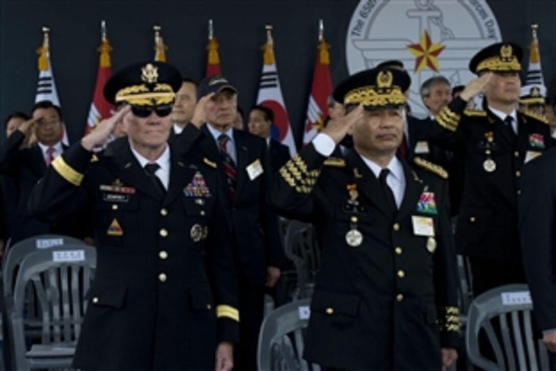 U.S. Army Gen. Martin E. Dempsey, left, chairman of the Joint Chiefs of Staff, salutes during the South Korean national anthem at a military parade to commemorate the 60th anniversary of the U.S.-South Korean alliance in Seoul, South Korea, Oct. 1, 2013.