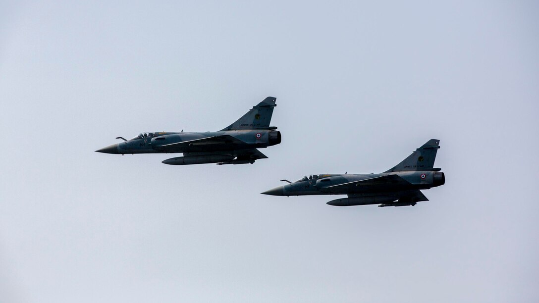 French Mirage 2000D jet fighters perform a show of force across the port side of the USS Kearsarge (LHD 3), at sea, Sept. 30, 2013. The 26th Marine Expeditionary Unit (MEU) is a Marine Air-Ground Task Force forward-deployed to the U.S. 5th and 6th Fleet areas of responsibility aboard the Kearsarge Amphibious Ready Group serving as a sea-based, expeditionary crisis response force capable of conducting amphibious operations across the full range of military operations. (U.S. Marine Corps photo by Sgt. Christopher Q. Stone, 26th MEU Combat Camera/Released)