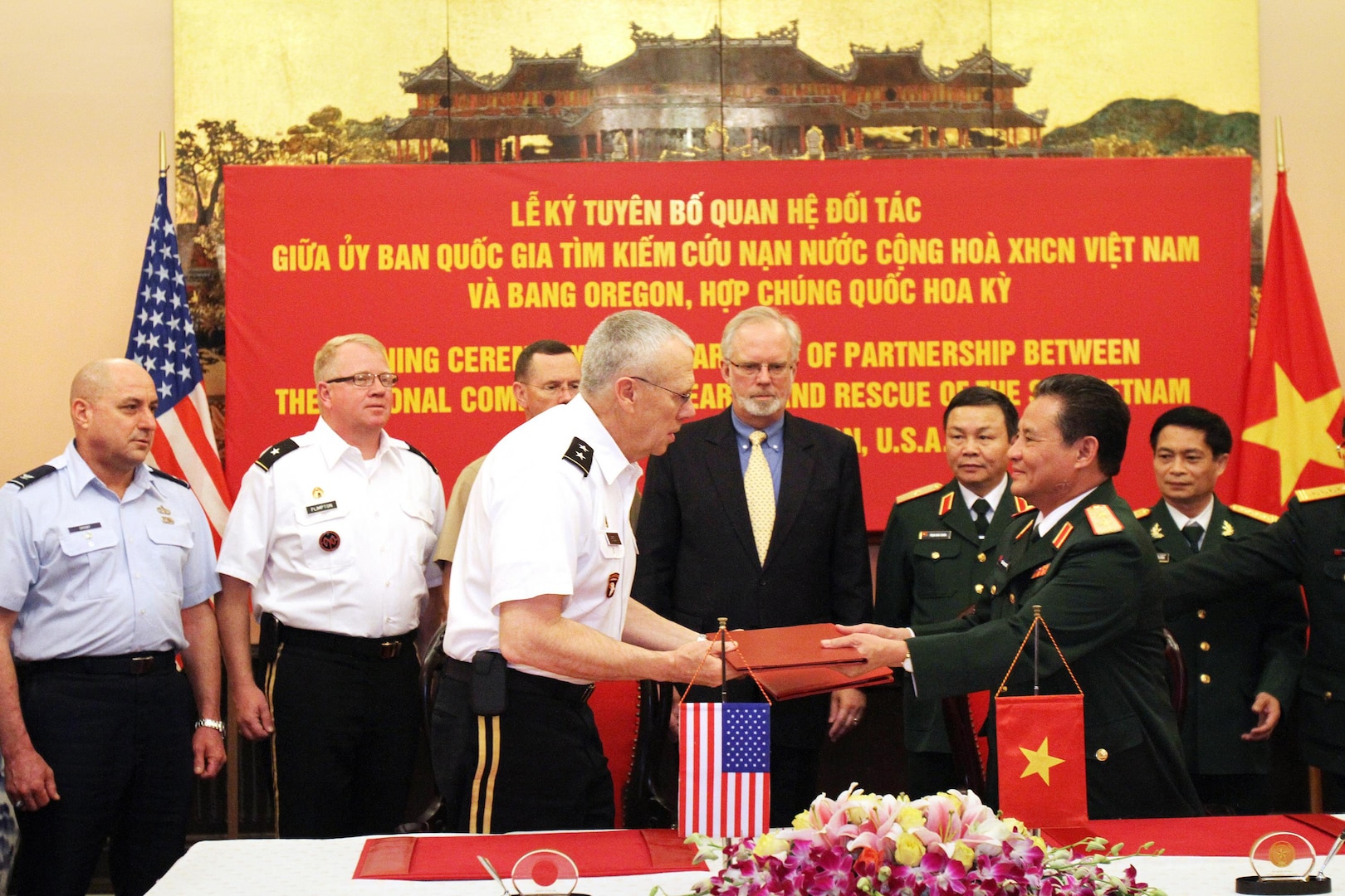 Oregon National Guard Maj. Gen. Raymond F. Rees, adjutant general, Oregon, and Vietnam Lt. Gen. Tran Quang Khue, vice chairman of the National Committee for Search and Rescue (VINASARCOM), congratulate each other following the official signing ceremony for the State Partnership Program between Oregon and Vietnam on Nov. 27, 2012.