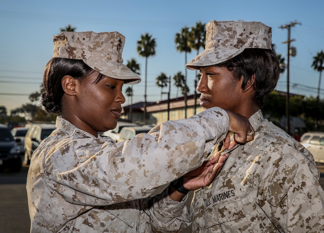Sergeant Whitney Murray, left, pins corporal chevrons on Cpl. Ashton M. Tyler, right, both warehouse clerks with the 15th Marine Expeditionary Unit, during a promotion ceremony held on the Camp Del Mar Parade Deck aboard Camp Pendleton, Calif., Oct. 1. Tyler, 21, is from Charleston, S.C. (U.S. Marine Corps photo by Cpl. Emmanuel Ramos/Released)