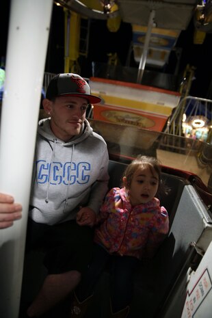 Brandon E. Sheppard and Gabriella M. Fuentes, Onslow County Fair patrons, look out on the country side as they ride the big ferris wheel during the fair, Sept. 30. “I love getting on the fast rides and the ones that make me feel like I’m flying,” said Fuentes, a 3-year-old fair patron.