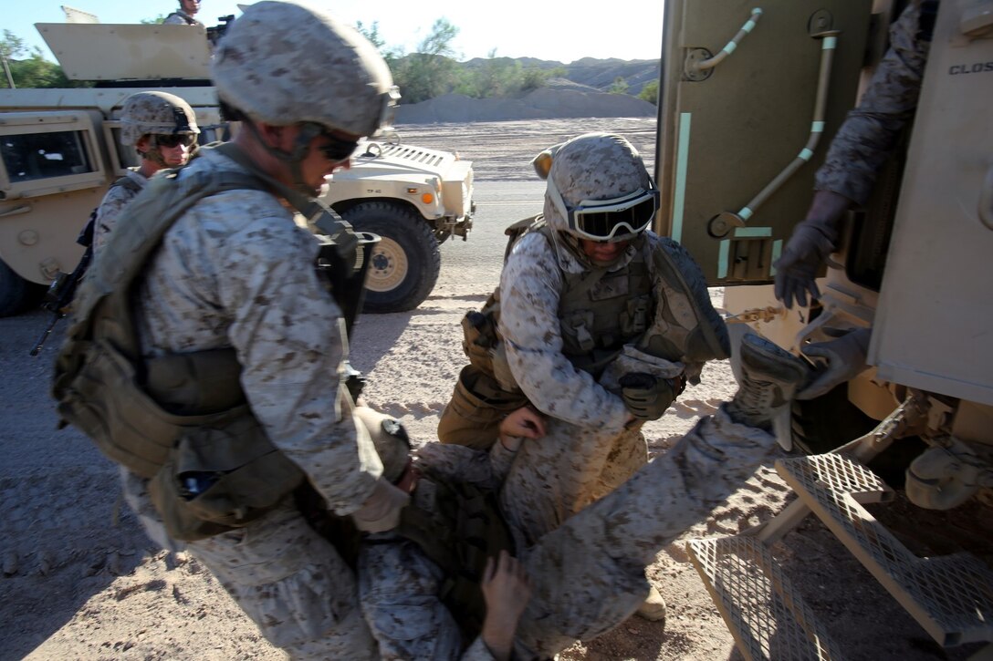 Marines with Baker Company, 1st Battalion, 7th Marine Regiment, evacuate a simulated casualty from inside a Mine Resistant, Ambush Protected All Terrain Vehicle during a training convoy here, Sept. 24, 2013. The Baker Co. Marines drove two MRAPs and two armored Humvees to a turnaround point nearly an hour away and then returned to their starting point. The convoy halted multiple times to simulate different situations such as a vehicle breaking down or hitting an IED.